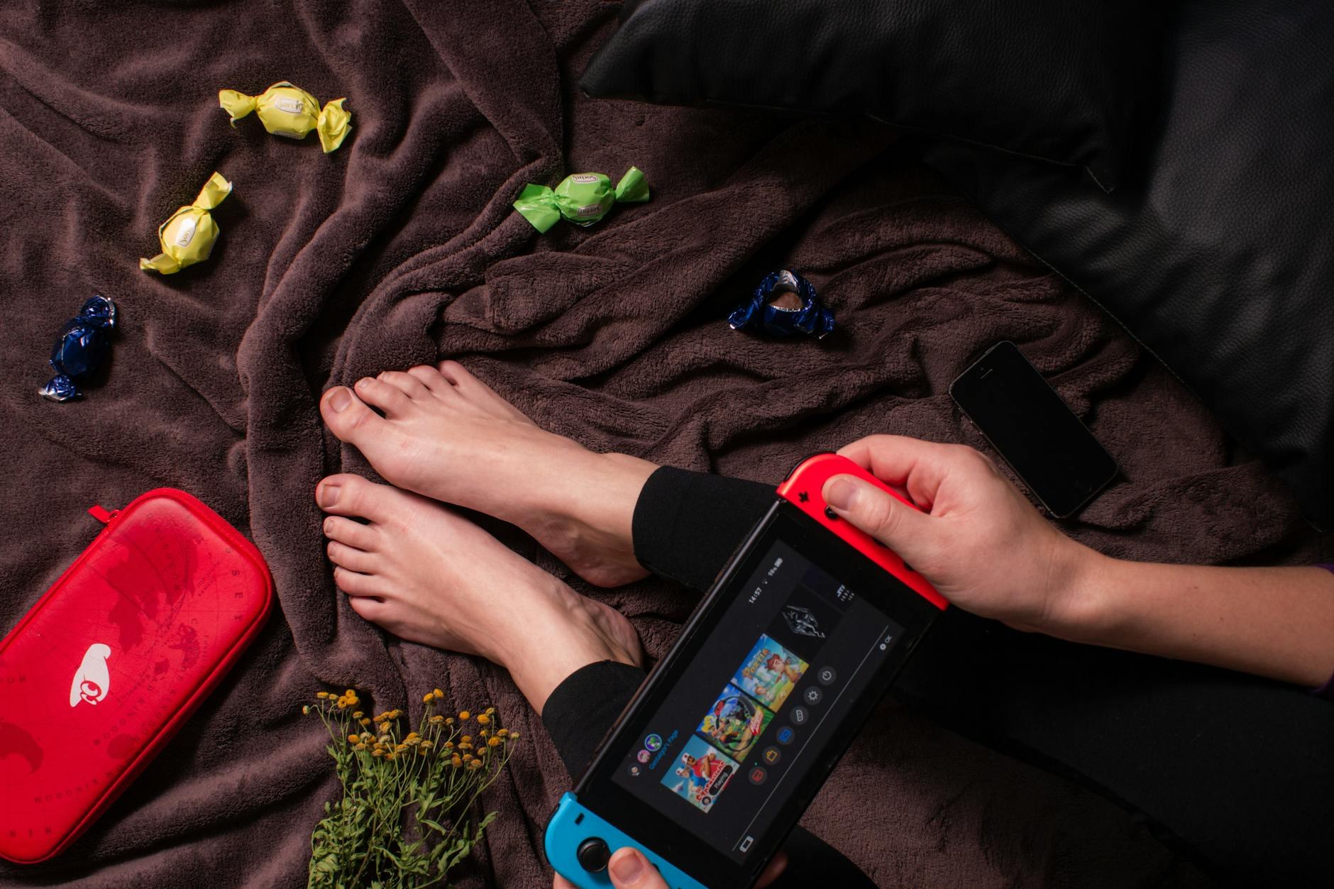 Cozy gaming desk setup with handheld device and warm lighting